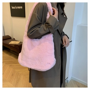 Sac fourre-tout en fausse fourrure rose avec large bandoulière porté par un mannequin