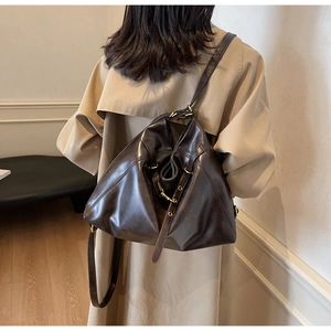 Detail of adjustable metal buckle and strap on dark brown leather versatile backpack