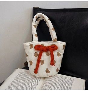 Detail of quilted cotton tote bag with brown bear pattern and orange rope bow decoration