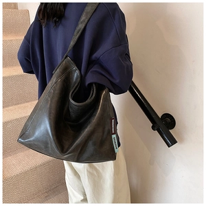 Macro detail of the dark brown distressed soft leather tote with chic striped ribbon