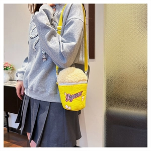 Detail of popcorn-themed crossbody bag with fluffy lamb wool trim and popcorn embroidery