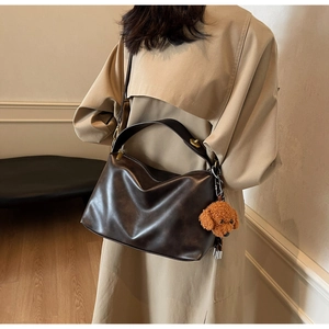 Detail of soft dark brown PU leather tote bag with a cute plush puppy pendant