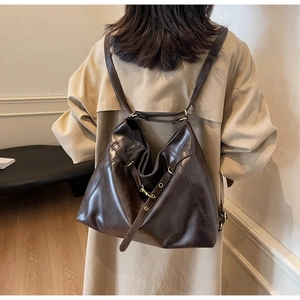 Detail of vintage brown large hobo bag with adjustable strap on beige trench coat