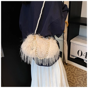 Close-up of beige plush crossbody bag featuring elegant pearl straps and woven bow detail
