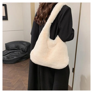 Détail d'un sac à bandoulière en fausse fourrure duveteuse blanc cassé porté par un modèle
