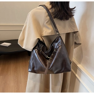 Detailed view of dark brown PU leather tote bag shoulder strap and premium metal eyelets