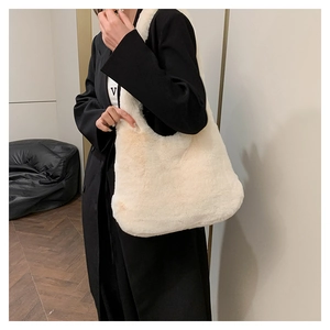 Vue détaillée du sac cabas en fausse fourrure blanc crème montrant sa texture douce au porté