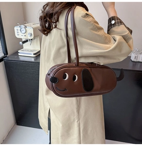 Sac bandoulière marron en forme de teckel en similicuir porté avec un trench d'automne