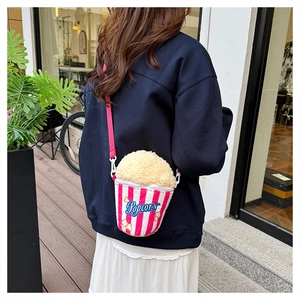 Detail showing the popcorn-shaped crossbody bag with fleece texture and pink striped fabric