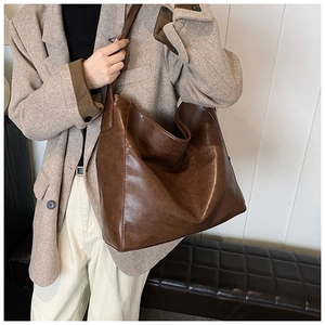 Macro detail of large brown vintage PU leather shoulder tote bag with smooth texture