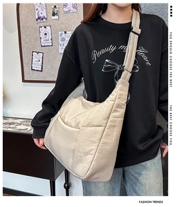 Detail of beige quilted dumpling bag showing the soft texture and adjustable strap