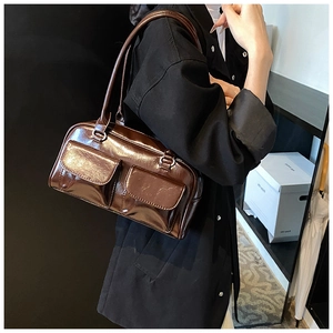Detail view of dark brown high-gloss faux leather shoulder bag with vintage double flap pockets