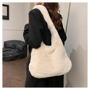 Détail d'un sac cabas en peluche ivoire porté avec un blazer noir pour un look d'automne