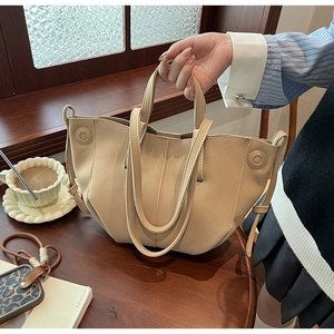 Detail of apricot PU leather handbag with pleated design and round button accent