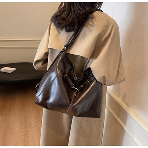 Detail view of large coffee brown PU leather tote bag with elegant gold metal buckle