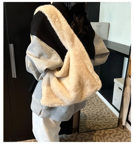 Détail du sac fourre-tout beige en fausse fourrure avec large bandoulière porté par un mannequin