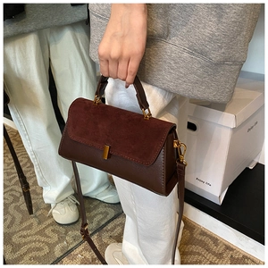 Detail of dark coffee PU matte shoulder bag with golden buckle and textured suede flap