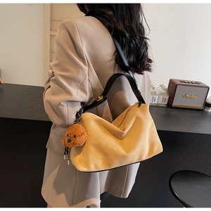 Chic yellow suede shoulder bag with plush teddy charm and adjustable black leather strap