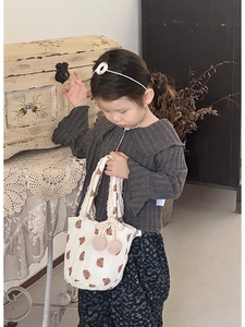 Détail du sac enfant en toile aux motifs d'ours avec dentelle et pompons roses