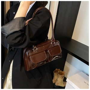 Detail view of dark brown gloss finish PU leather shoulder bag with two front pockets