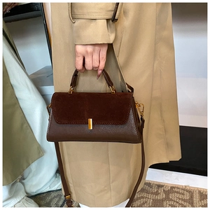Close-up of vintage brown PU leather handbag with matte suede texture and gold buckle