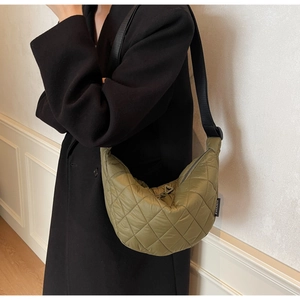 Detailed close-up of olive green quilted crescent moon bag with textured stitch patterns