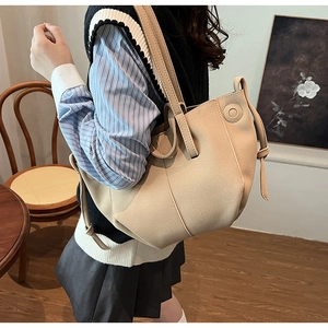 Detail view of beige large-capacity PU leather tote bag with unique fold-over side knot design