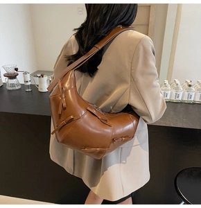 Gros plan sur le sac croissant en cuir marron avec détails de nœuds élégants et bandoulière