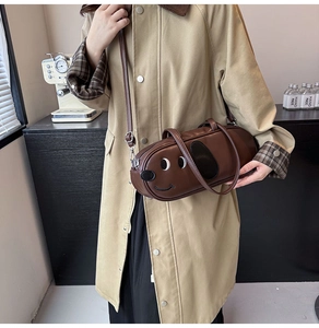 Détail du sac cylindrique en cuir PU marron avec motif de visage de chien brodé