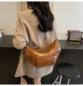 Sac bandoulière demi-lune en cuir PU marron avec nœuds élégants porté par mannequin