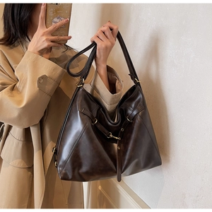 Detail view of the large chocolate brown PU leather tote bag with gold metal hardware details
