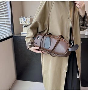 Détail du sac bandoulière en similicuir marron en forme de teckel avec manteau kaki