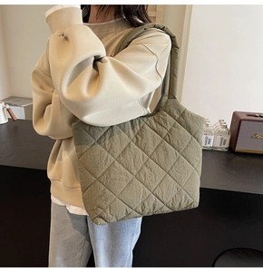 Detail of olive green quilted tote bag with classic diamond pattern and wide shoulder strap