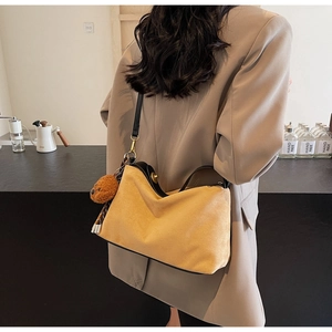 Chic mustard PU crossbody bag with plush bear charm worn by model in beige suit