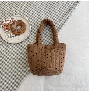 Close-up of brown polka dot quilted cotton tote bag on a rustic plaid tablecloth scene