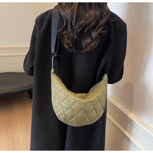 Detail of olive green quilted crescent bag with adjustable wide strap on model back