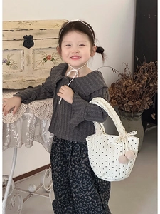 Détail du pantalon floral pour enfants avec un sac à main à pois et un décor de pompon