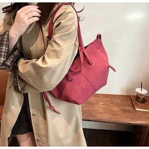 Detail view of dark red PU tote bag with vertical stitching and round embossed textures