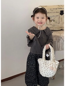 Détail d'un enfant portant un haut en tricot à col volanté et un pantalon à fleurs