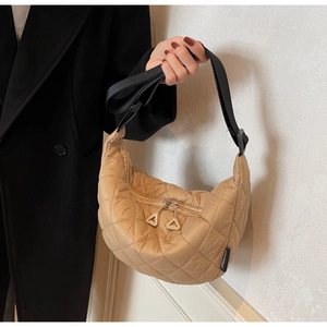 Detail of khaki quilted crescent bag with diamond stitching and adjustable strap