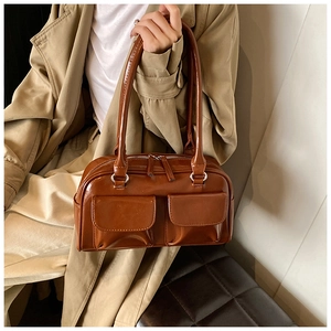 Brown faux leather shoulder bag featuring dual front flap pockets and glossy finish