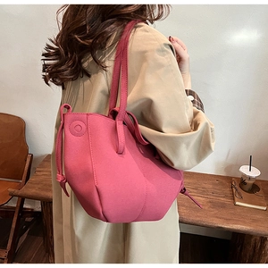 Detail view of stylish fuchsia faux suede tote bag with decorative side drawstring design