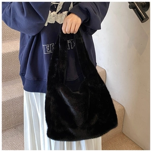 Détail d'un sac cabas en fausse fourrure noire duveteuse avec une texture douce d'automne