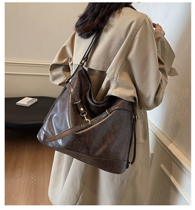 Detail view of retro brown PU leather shoulder bag with vintage brass buckles and eyelets