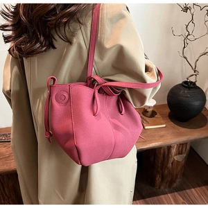 Close-up of rose pink PU leather bucket bag with drawstring details and matte finish