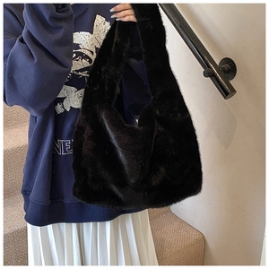 Détail d'un sac bandoulière en fausse fourrure noire douce avec bandoulière intégrée