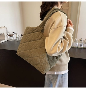 Detail showing olive green quilted shoulder bag with diamond stitching in a lifestyle setting