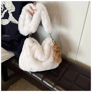 Détail du sac bandoulière en peluche blanche avec breloque ours et boucles métal