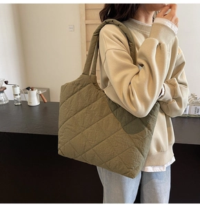Detailed close-up of an olive green quilted tote bag with diamond stitching texture