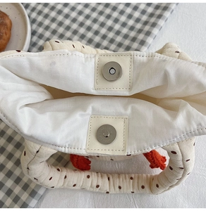 Detail view of the cotton quilted shoulder bag showing interior lining and magnetic clasp